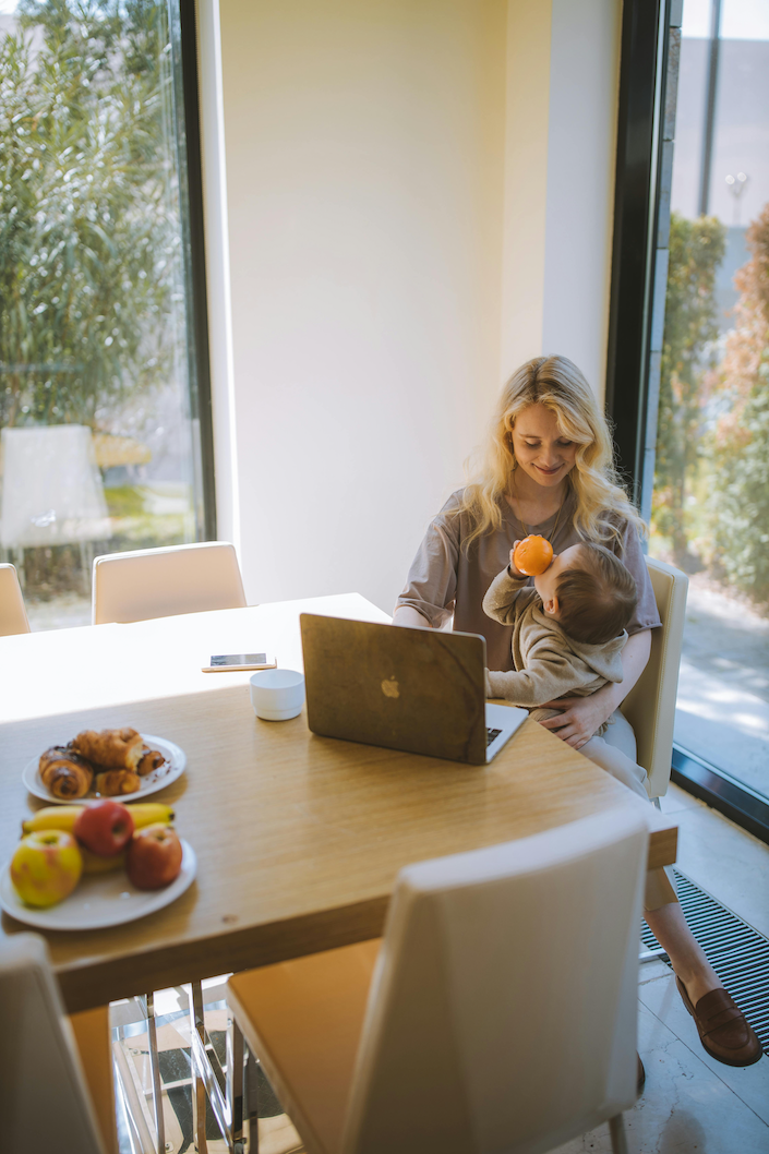 Mother holding child in front of laptop