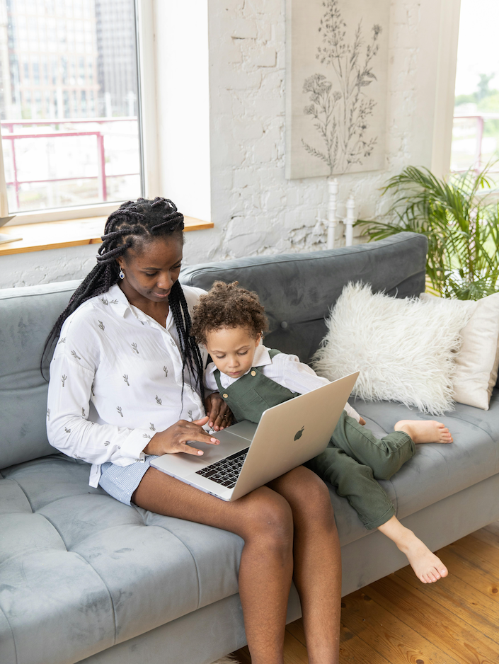 Mother sitting with child in front of laptop